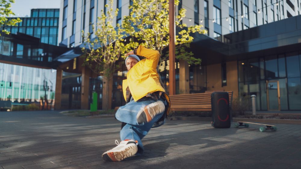 Dynamic Outdoor Scene Capturing A Young Male Breakdancer In Mid-air, Performing An Energetic Move