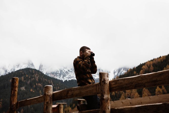 Man with camera standing in beautiful mountains landscape