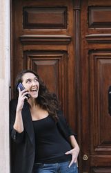 Young female using mobile phone on wooden door