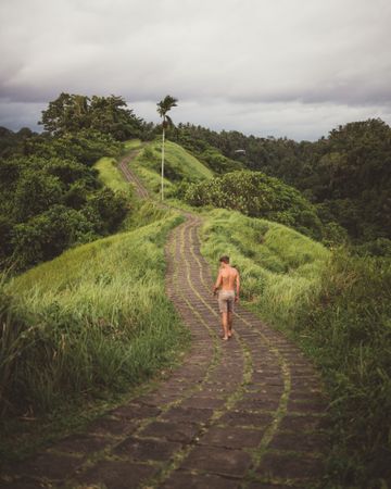 Traveler on paved roadway in tropical mountains
