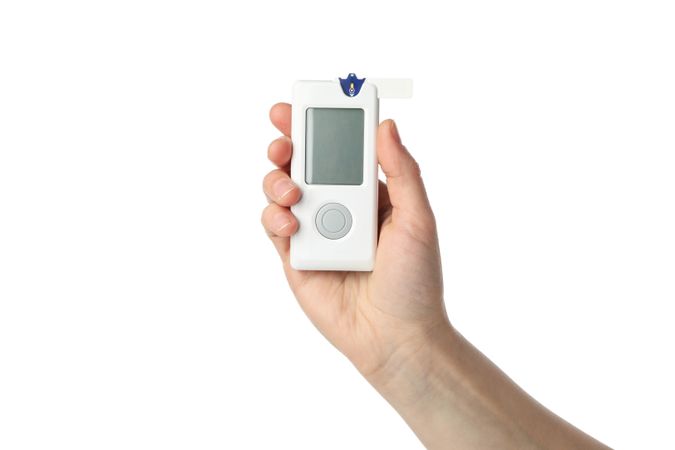 Female hand holds blood glucose meter, isolated on white background