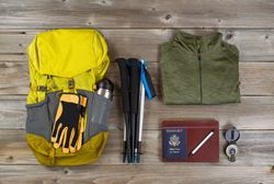 Backpack with walking accessories on rustic wood