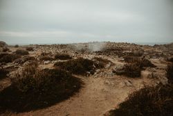 Crater between land and cloudy sky