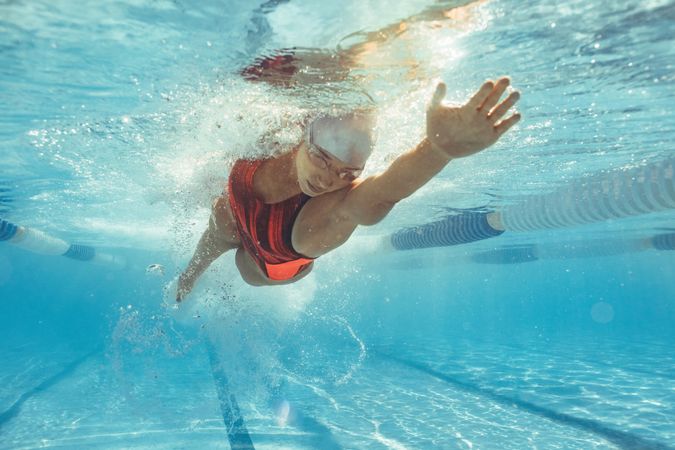 Young woman swimming the front crawl in a pool