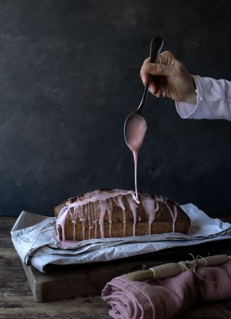 Hand pouring creme on delicious orange cake