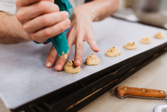Crop baker squeezing dough on tray