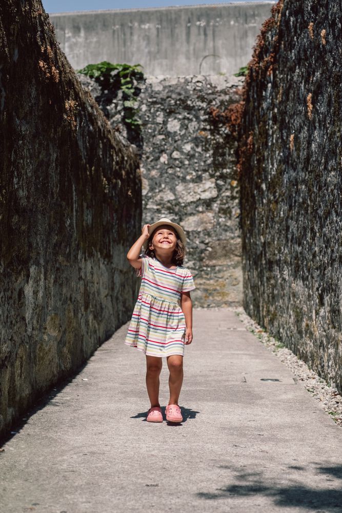 Girl in narrow stone walkway looking up