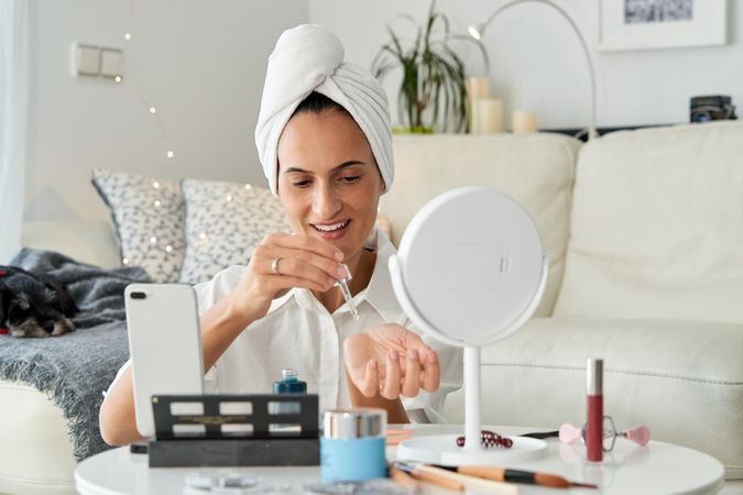 Positive woman beauty blogger testing cosmetic serum in live bro