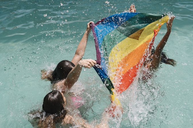 Anonymous lesbians splashing in swimming pool