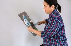 Builder working picking plaster with spatula