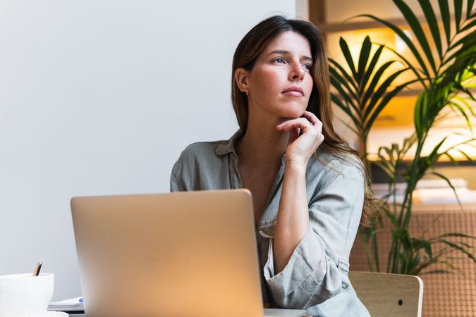 Woman surfing internet on laptop at cafe table