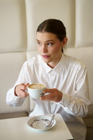 Woman in modern cafe sipping coffee