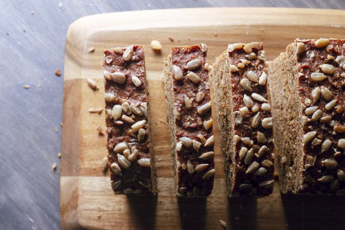 Sliced wholegrain bread on wooden cutting board