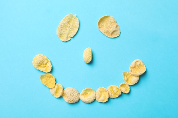 Smiley face made of muesli on blue background