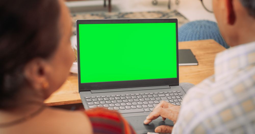 Back View of Indian Mature Couple Using Laptop with Green Screen: Chroma Key Browsing Internet