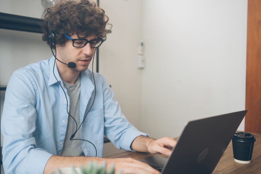 Male telemarketing talking to customer working at home