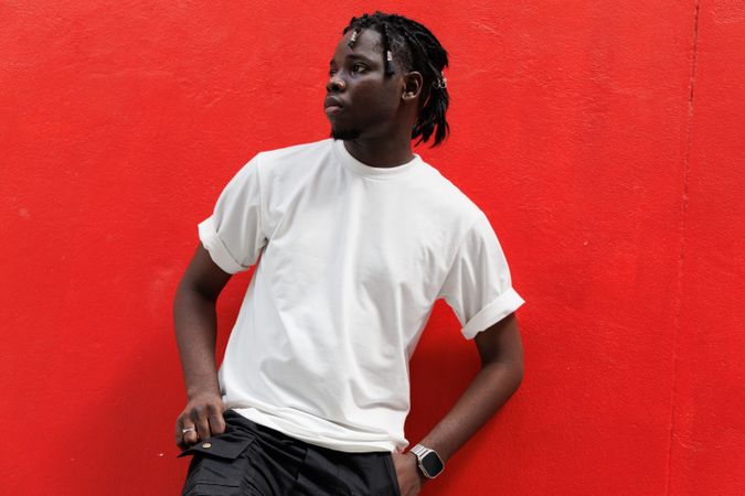 Black male standing with red background