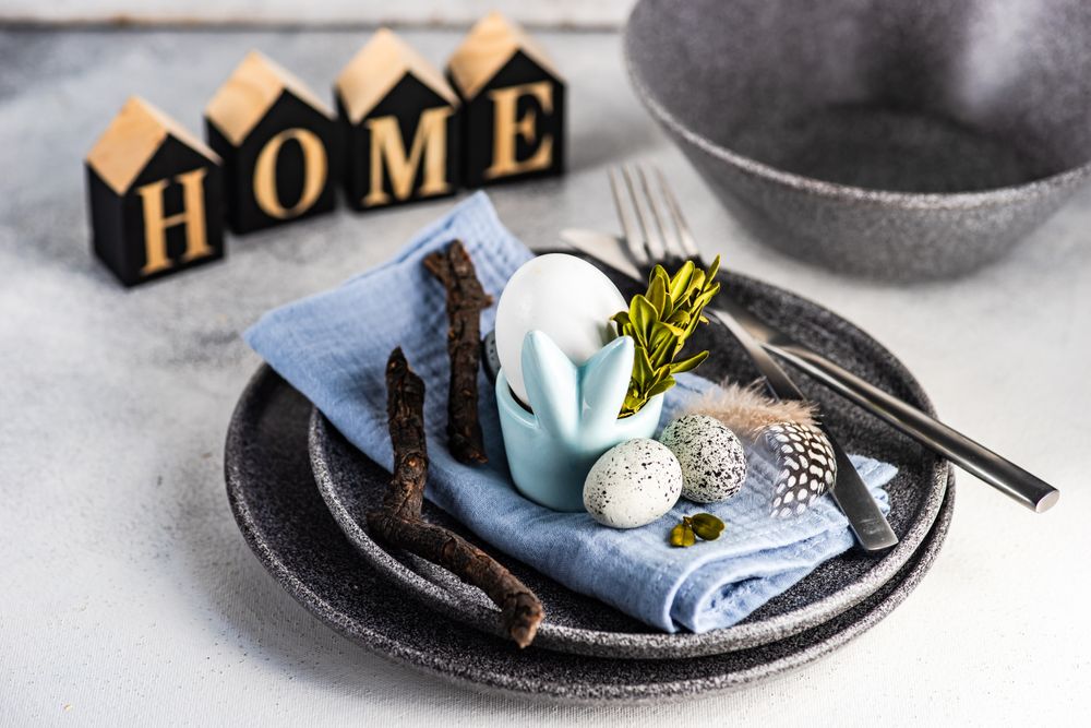 Easter table setting with eggs, branch and feather