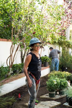 Female contractor landscaping a backyard garden