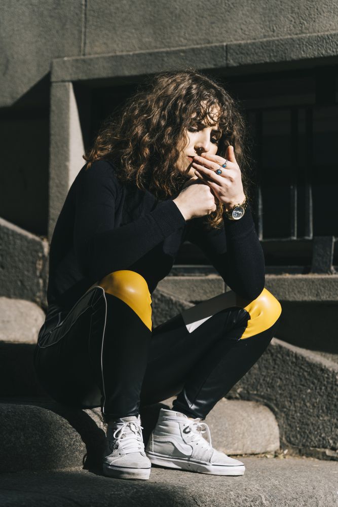 Young woman smoking cigarette in the street
