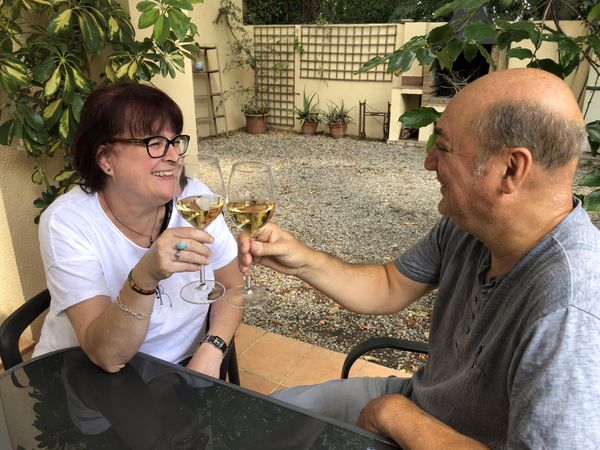 Middle aged man and woman celebrating and cheering with wine