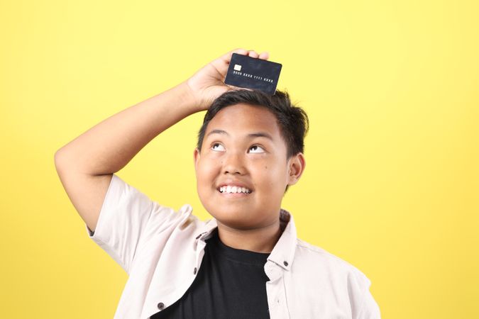 Asian Boy Holding Black card Above His Head