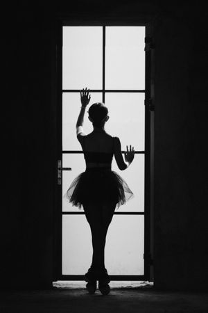 Ballerina standing on window pane