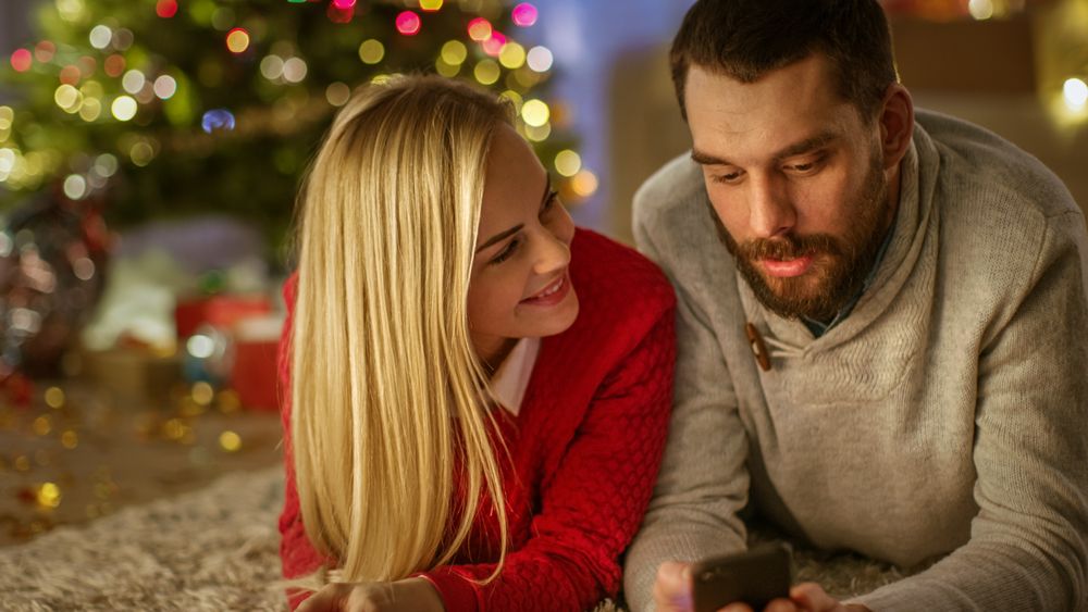 Happy Lovely Couple Lies On the Carpet Under Christmas Tree