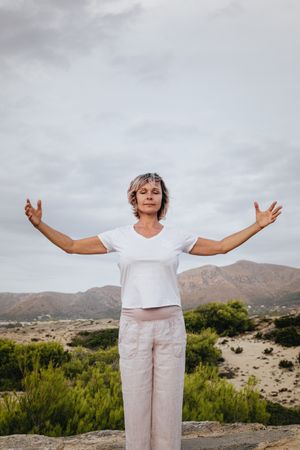 Barefoot woman meditating on stone