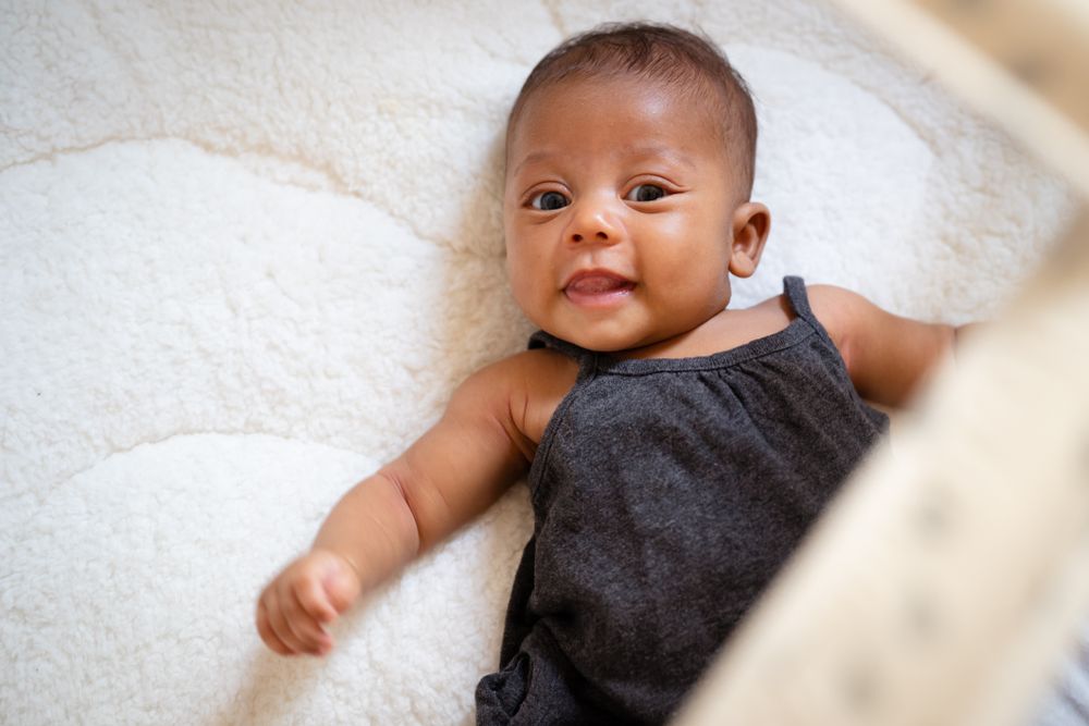 Cute female baby smiling and lying on her back