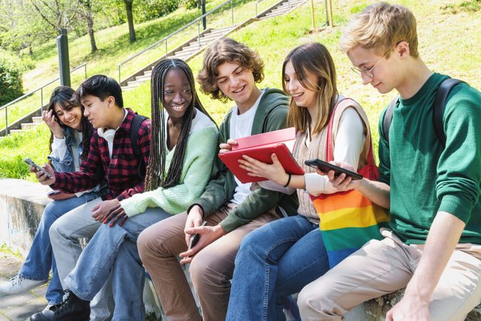 Multi-ethnic group of students sitting outside on campus