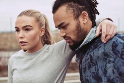 Focused woman resting with her arm over her boyfriends neck