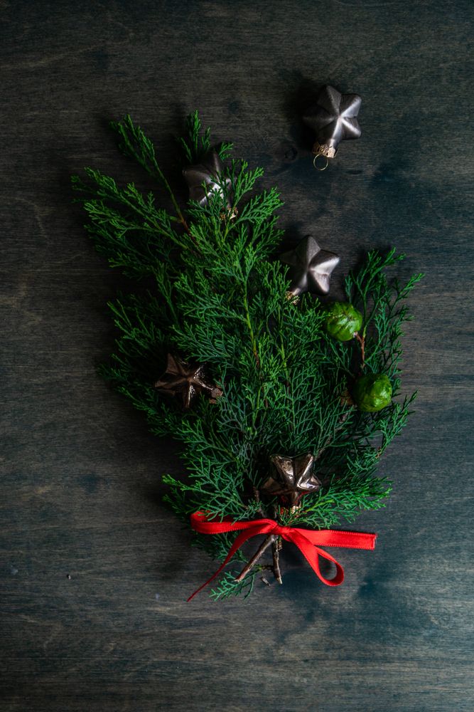 Tree branch with Christmas ornaments on wooden table