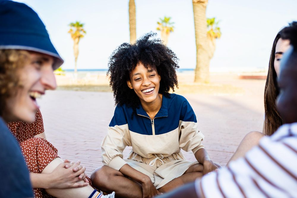 Group of young adults talking and having fun together outdoors