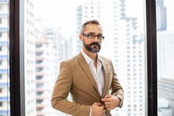 Man in office adjusting his jacket