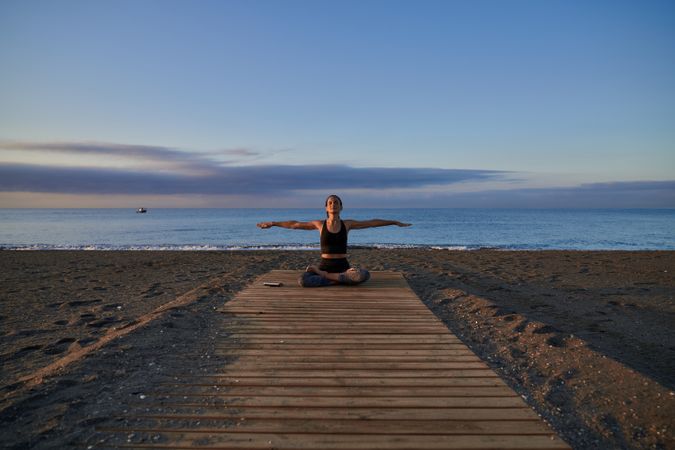 Woman in lotus pose near sea