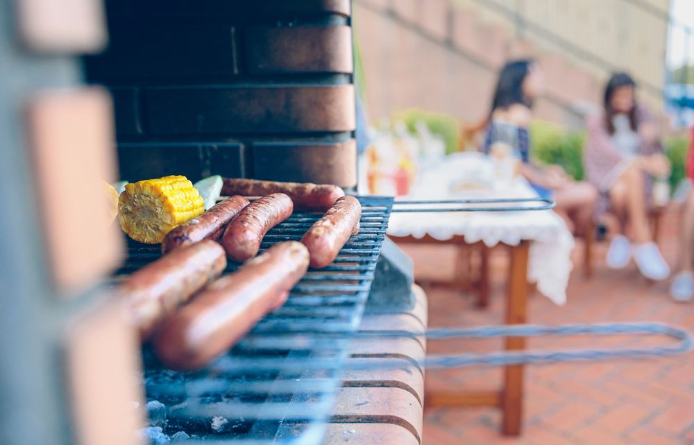 Sausages and corn cobs cooked in a barbecue