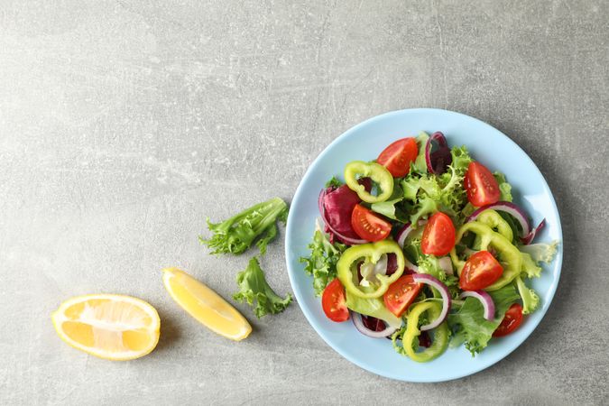 Salad of fresh vegetables on grey background, top view