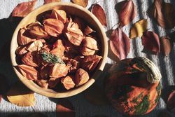 Bowl of physalis fruit in bowl on picnic table with fall leaves