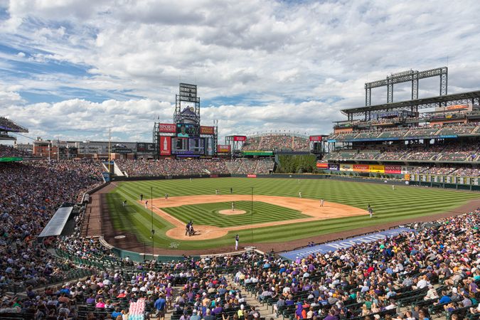 Baseball game in packed stadium at Coors Field