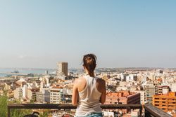 Woman on balcony looking at city views from above