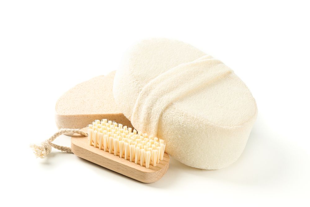 Wooden bath brush and sponges isolated on plain background