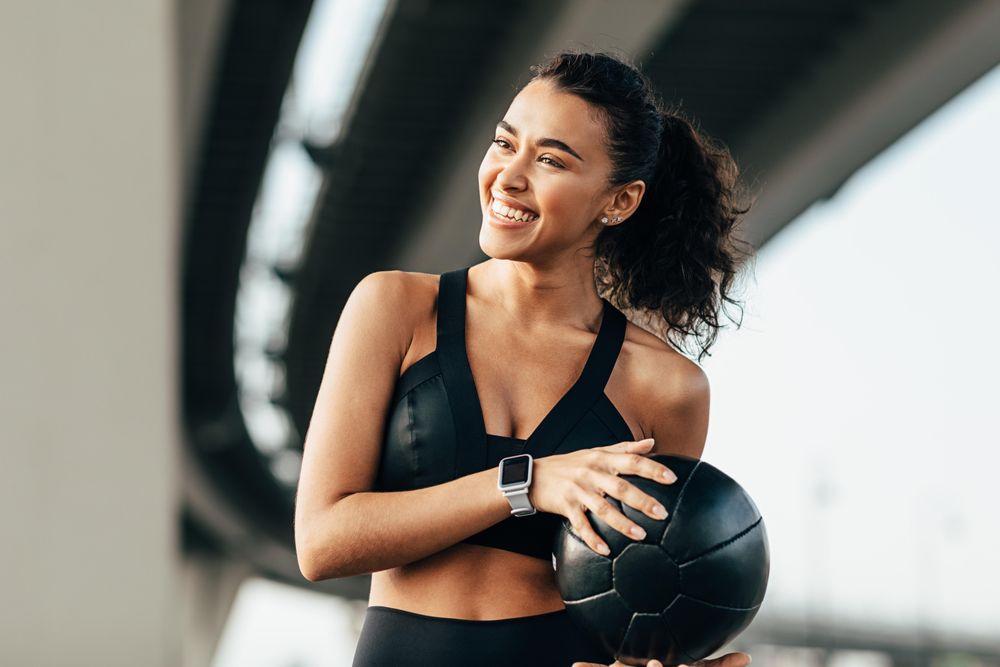 Smiling fit woman with medicine ball