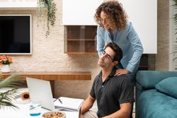 Content woman giving massage to partner at home