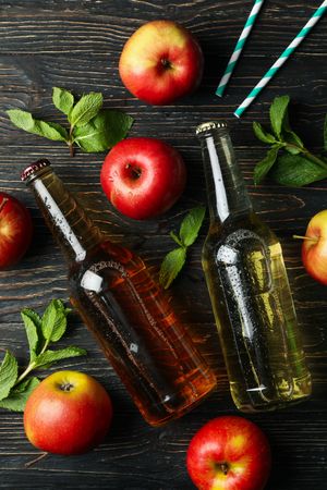 Composition with cider, apples and straws on wooden background
