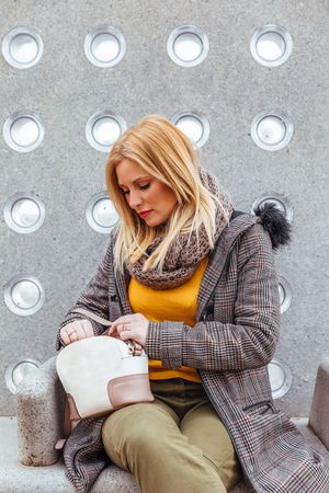 Portrait of blond woman looking in her bag