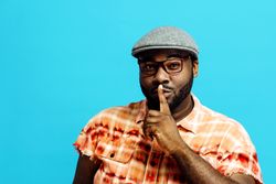 Man with finger over his mouth asking for silence, secret