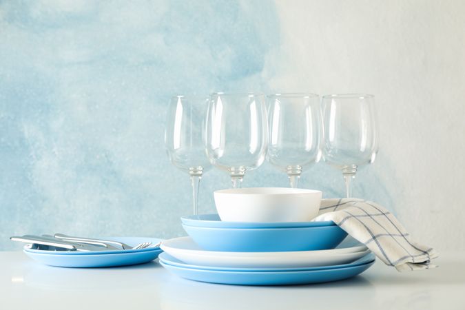 Cutlery beautifully stacked on table against blue background
