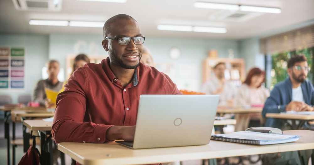 Adult Education Center: Black Student Learning in Classroom And Smiling