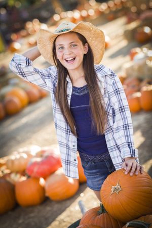Preteen Girl Playing with a Wheelbarrow at a Pumpkin Patch.